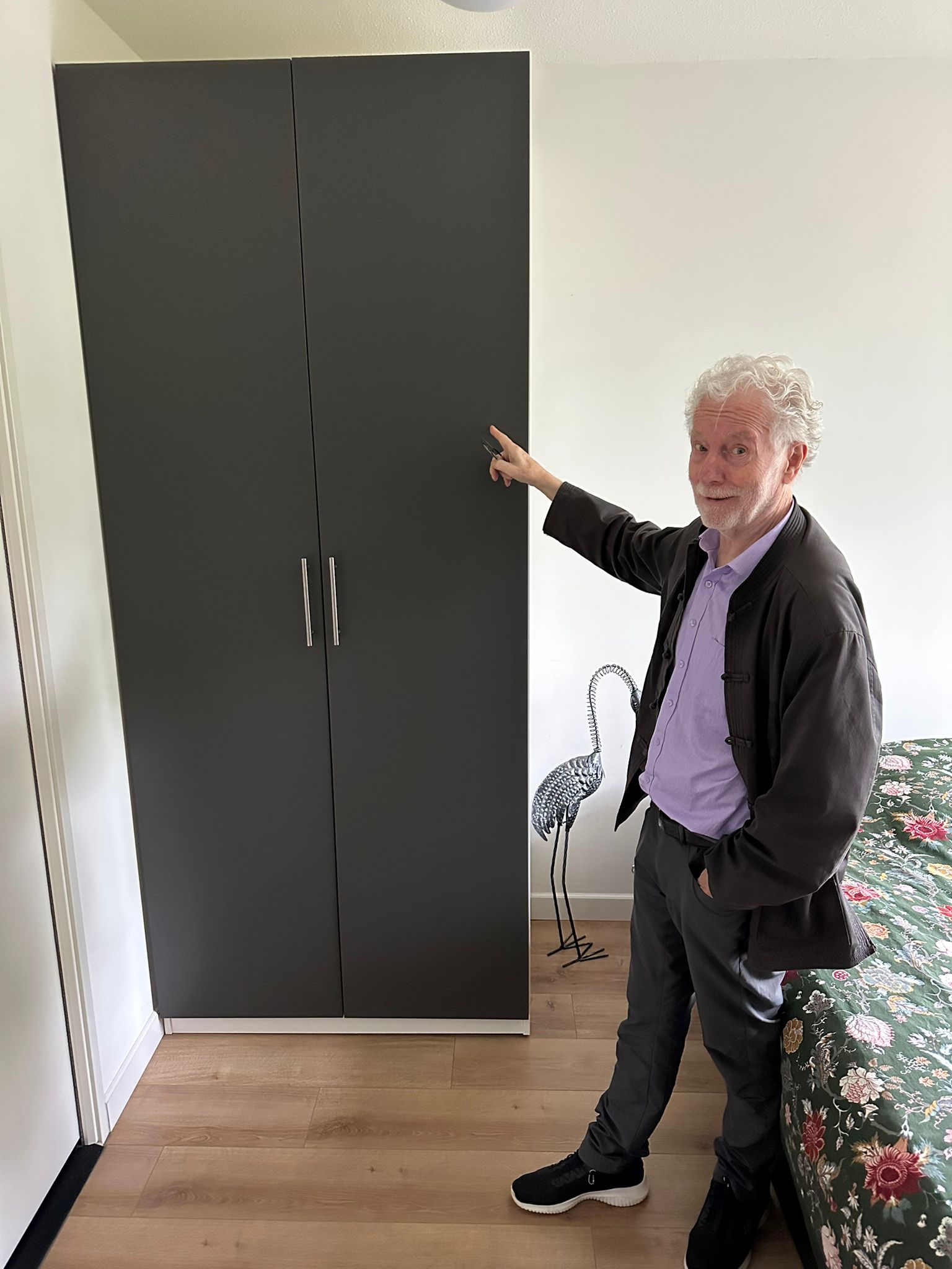 Hoge grijze kledingkast gemonteerd in slaapkamer